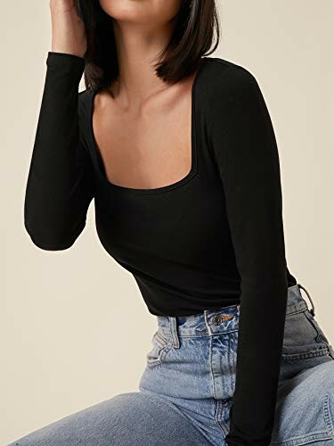 Woman wearing black long-sleeve top and jeans.